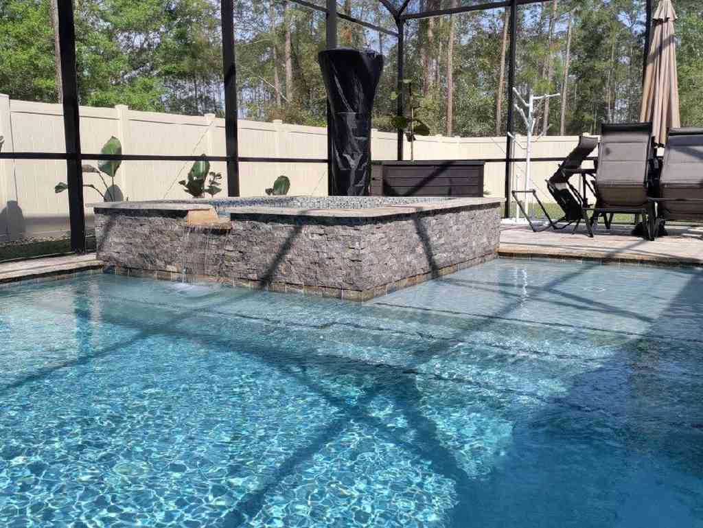 Custom pool with raised spa and sun deck.