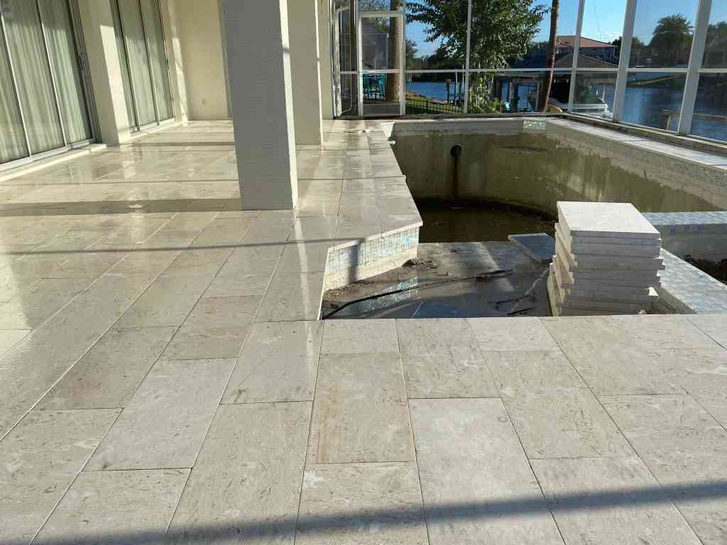 Travertine pavers installed over concrete subdeck for a full pool remodel in Palm Coast