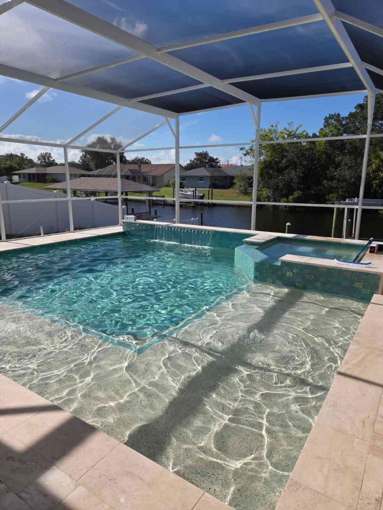 Custom pool and spa combo in Palm Coast featuring sun deck and raised-wall water feature