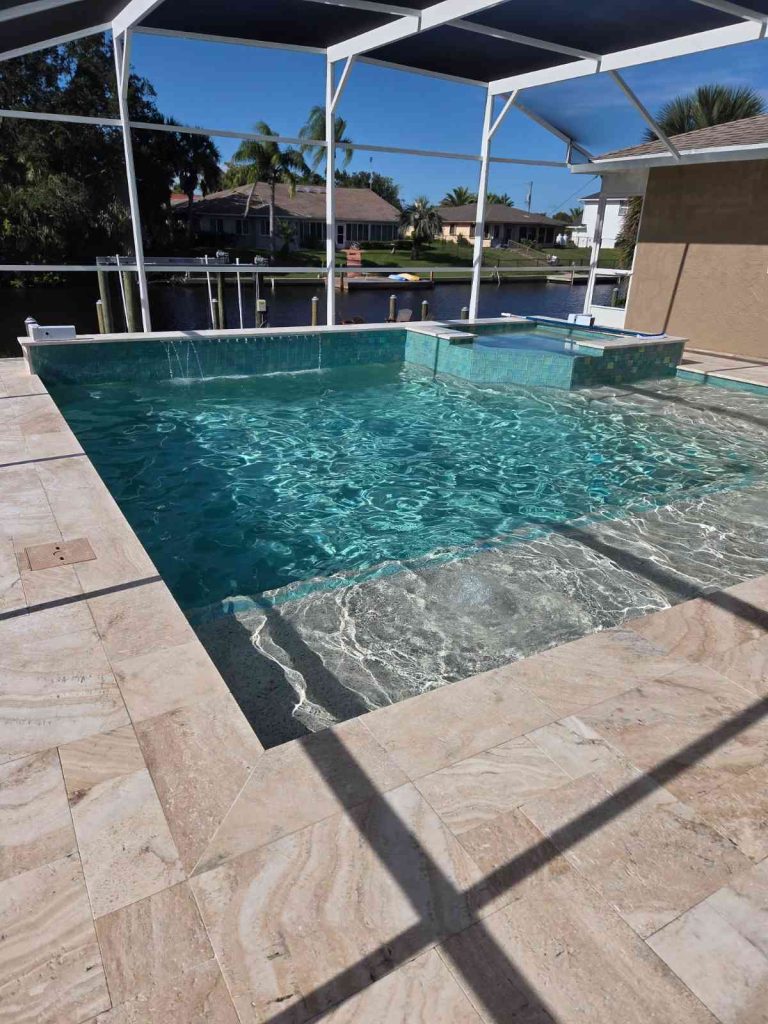 Custom pool and spa combo in Palm Coast featuring sun deck and raised-wall water feature