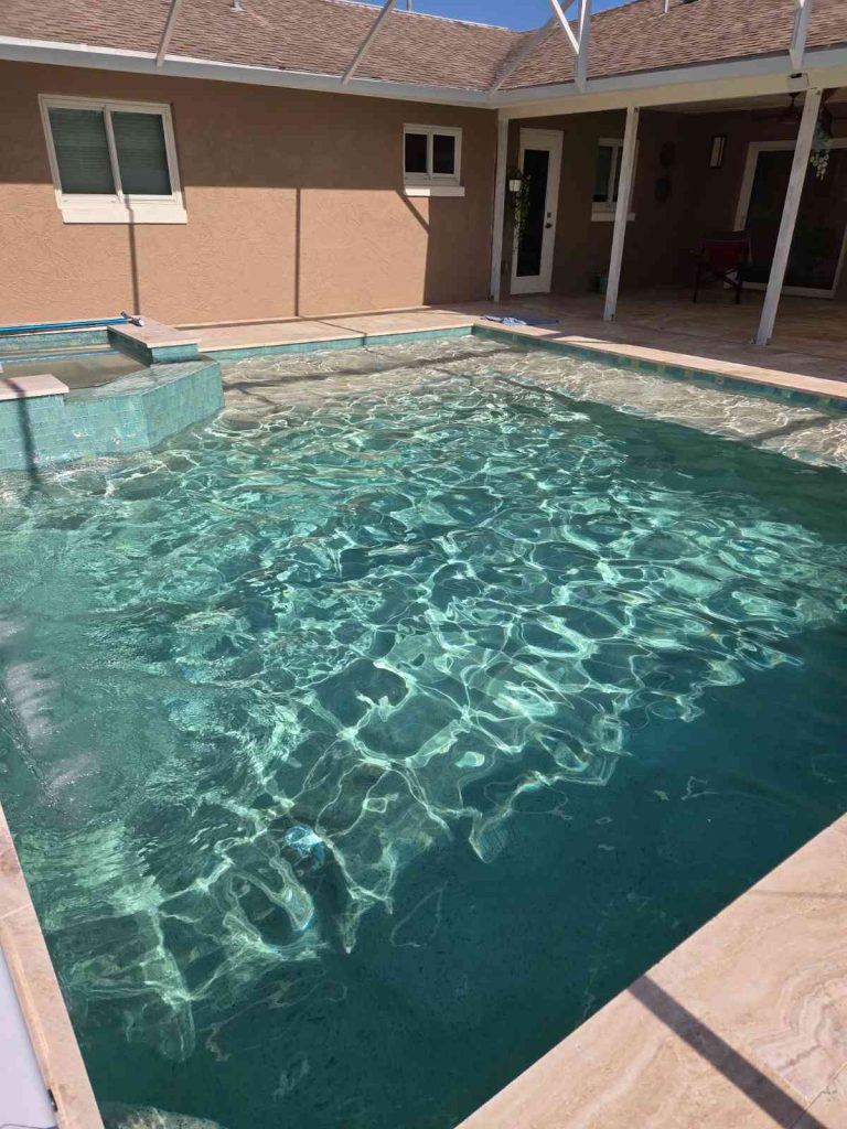 Custom pool and spa combo in Palm Coast featuring sun deck and raised-wall water feature
