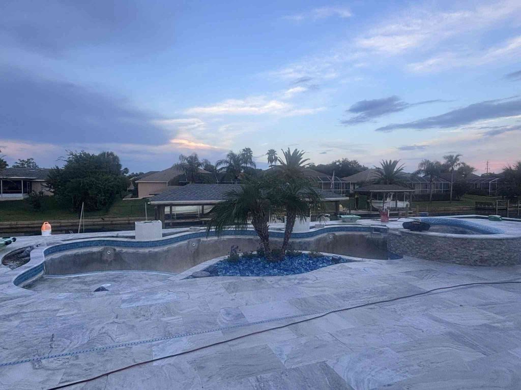 Custom luxury freeform pool with raised spa, sun deck, and fire bowls