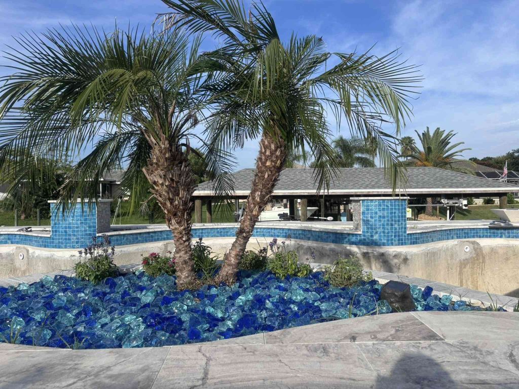 Custom luxury freeform pool with raised spa, sun deck, and fire bowls